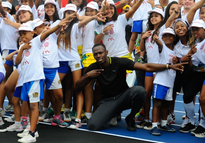 Usain Bolt corre com crianças de comunidade pacificada