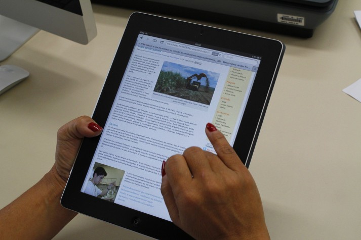 Mãos de mulher navegam na Internet em um tablet
