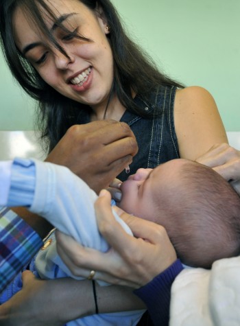 A biomédica Juliana de Paiva segura o filho Lorenzo, 2 meses, que recebe a primeira dose da vacina contra a poliomielite 