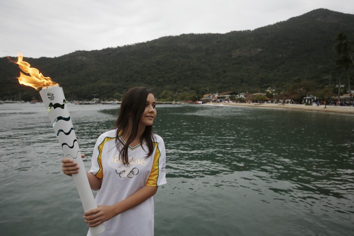 A condutora Maíra dos Santos leva a tocha olímpica em Ilha Grande