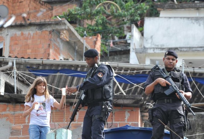 riança da comunidade do Morro dos Macacos, em Vila Isabel, oferece água ao policial do Bope, durante instalação da Unidade de Polícia Pacificadora