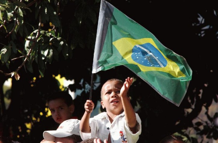 Criança brinca com a bandeira do Brasil