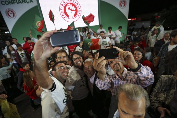 O Secretário-Geral do Partido Socialista português (PS) Antonio Costa posa para um selfies com grupo durante um comício 