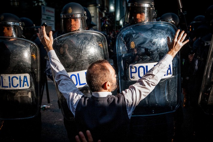 Manifestante em frente a barreira de policiais durante prostesto na Espanha