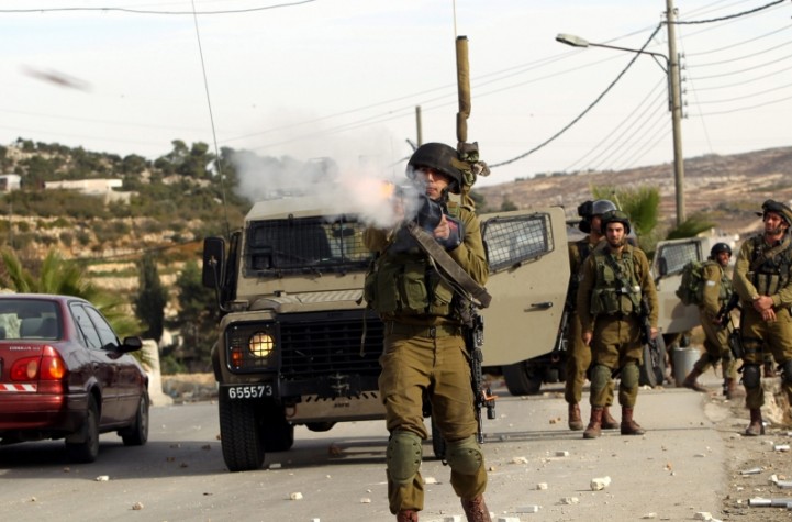 Soldado israelense atira bomba de gás lacrimogêneo em manifestantes palestinos 