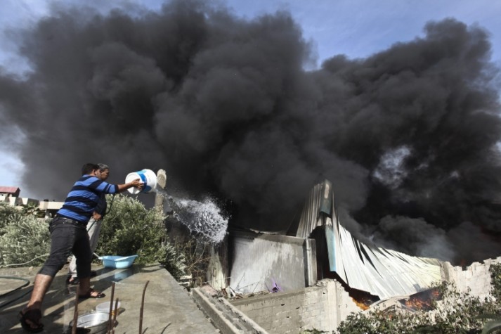  Povo palestino tentar extinguir o fogo depois de um ataque aéreo israelense