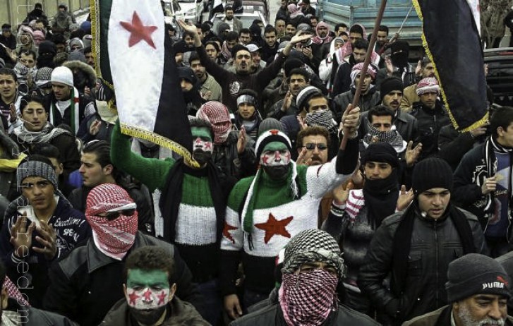 Multidão protesta com bandeiras da Síria e rostos cobertos