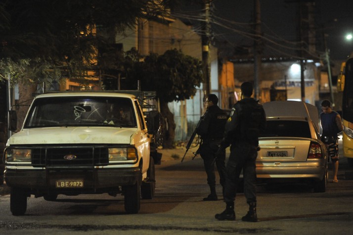 Policiais militares revistam carros na entrada da Vila Kennedy